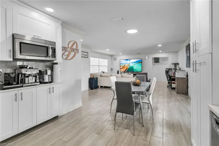Dining area with light wood-type flooring and crown molding