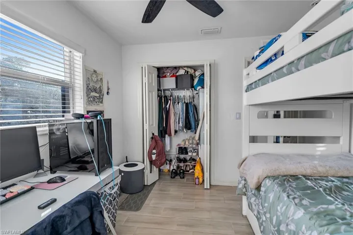 Bedroom with ceiling fan, light hardwood / wood-style floors, and a closet