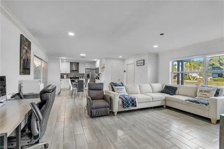 Living room featuring crown molding and light wood-type flooring