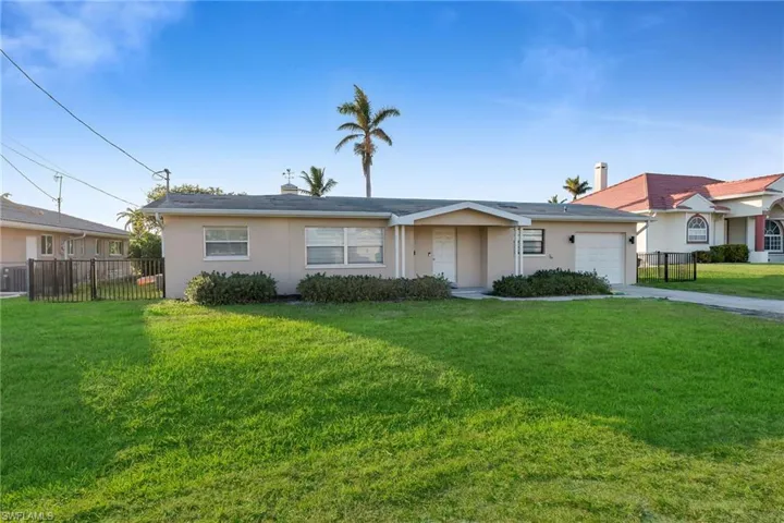 Ranch-style house featuring a front yard and a garage