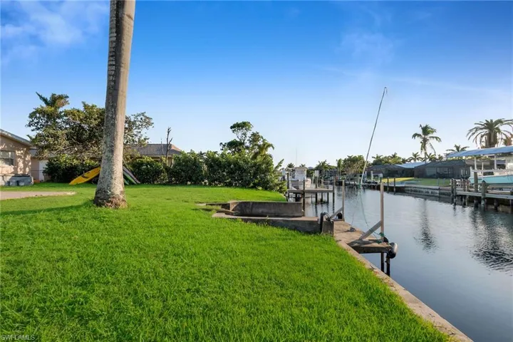 View of dock featuring a yard and a water view
