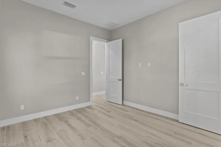 Unfurnished bedroom with wood finish floors and baseboards