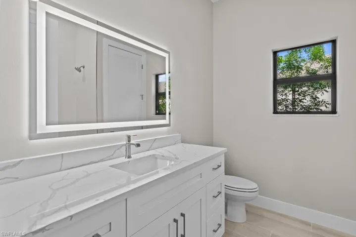 2nd Bathroom featuring toilet, vanity, baseboards, and wood finished floors