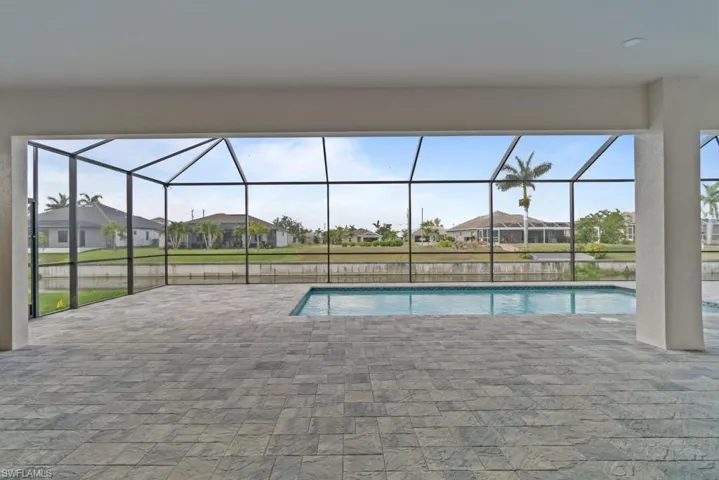 Swimming pool featuring a patio area, a residential view, and glass enclosure