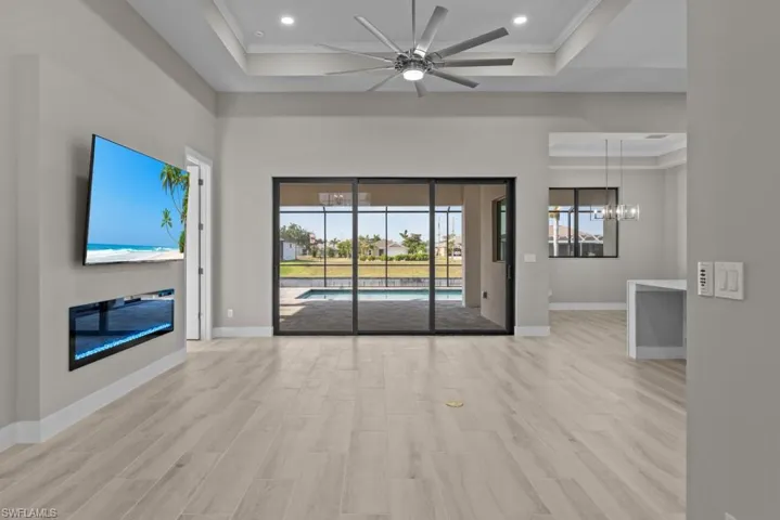 Unfurnished living room featuring ornamental molding, wood finished floors, plenty of natural light, a chandelier, and recessed lighting