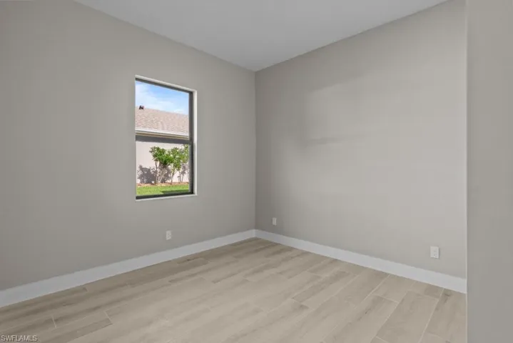 Unfurnished room featuring wood finish floors and baseboards