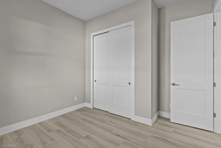 3rd Bedroom with wood finish floors, baseboards, and a closet