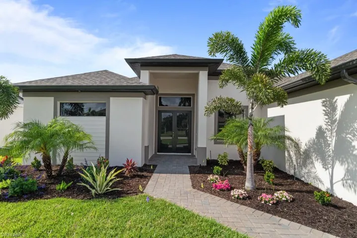 View of exterior entry with french doors, stucco siding, and a shingled roof