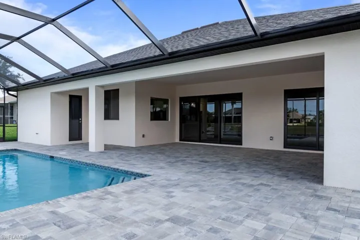 Rear view of house with a patio area, an outdoor pool, a lanai, and stucco siding