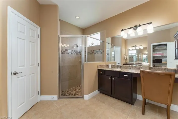 Primary bathroom with dual vanities & walk-in shower.