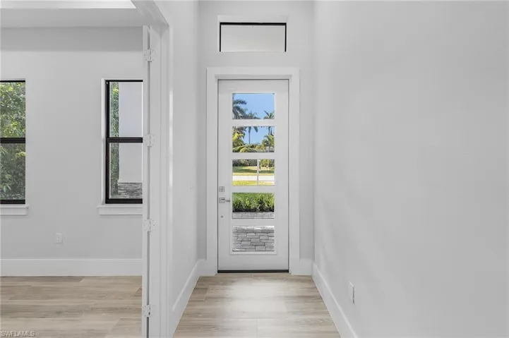 Doorway featuring wood finished floors and baseboards