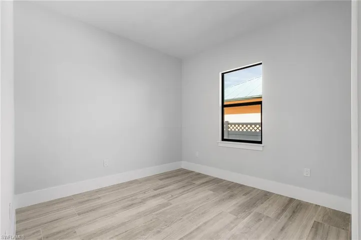 Unfurnished room with light wood-style floors and baseboards
