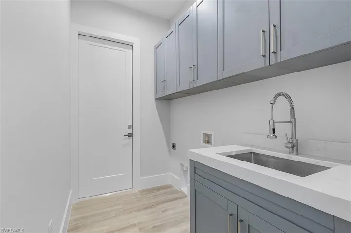 Laundry area with light wood finished floors, electric dryer hookup, cabinet space, and hookup for a washing machine