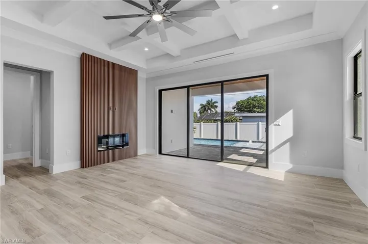Unfurnished living room with coffered ceiling, a ceiling fan, recessed lighting, light wood-style flooring, and a fireplace