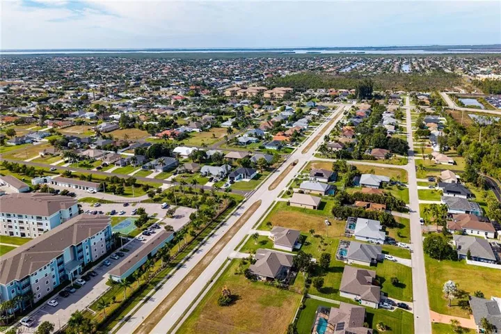 Aerial view of property and surrounding area with nearby suburban area