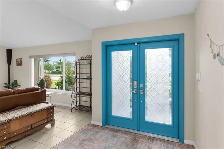Entryway with light tile patterned floors and baseboards