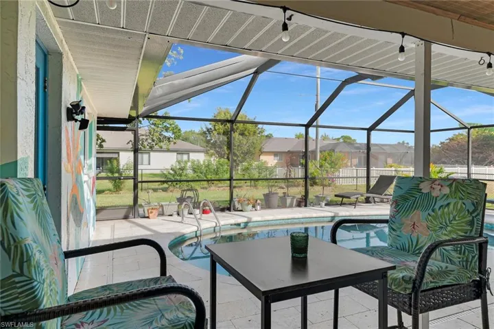View of patio featuring a lanai, a sunroom, an outdoor pool, and a residential view
