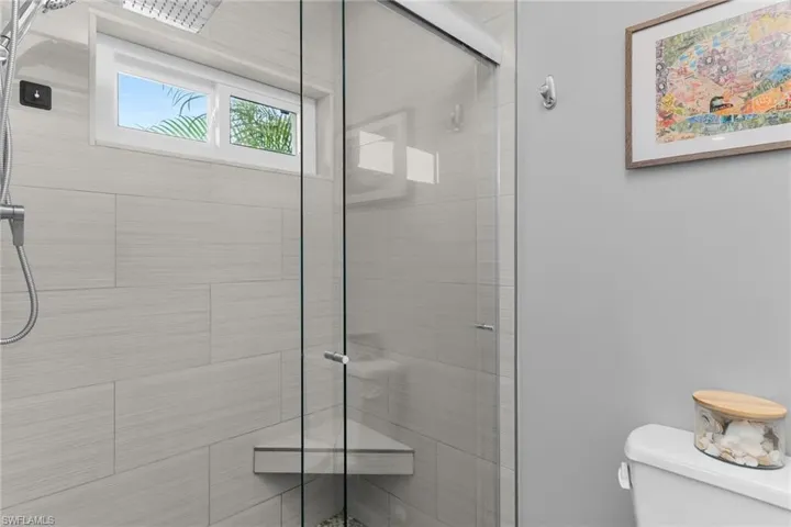 Full bathroom featuring a stall shower and toilet