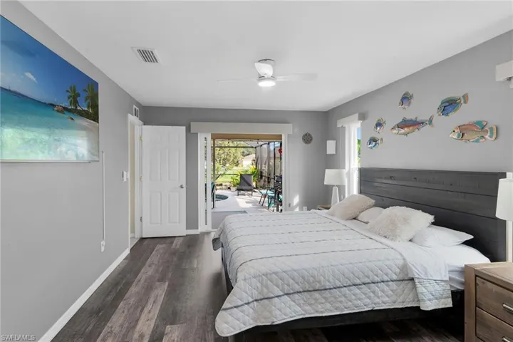 Bedroom featuring access to outside, dark wood-style flooring, and a ceiling fan