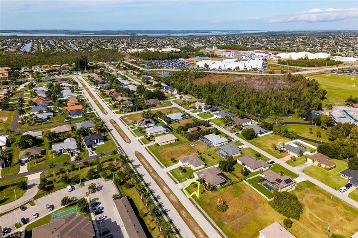 Aerial view of property and surrounding area with nearby suburban area and a large body of water