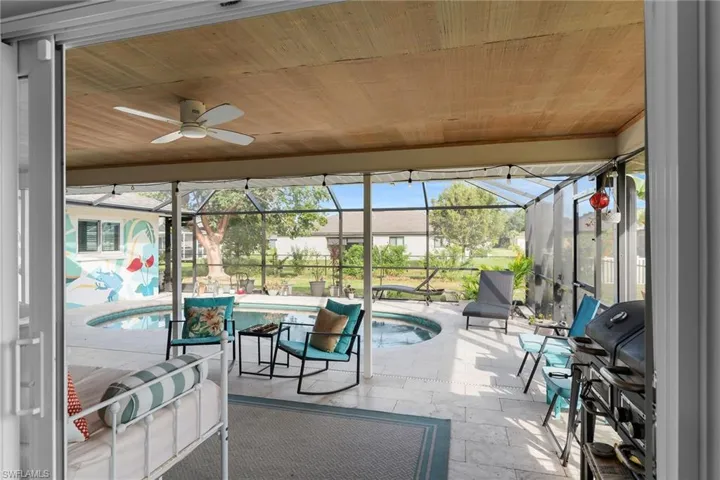 Sunroom / solarium featuring a patio, a ceiling fan, and a jacuzzi