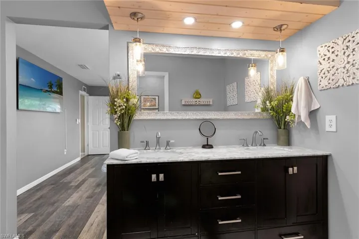 Bathroom featuring double vanity, wood ceiling, dark wood finished floors, and recessed lighting