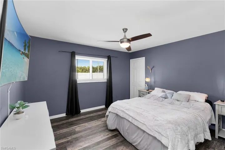 Bedroom with ceiling fan and dark wood-type flooring