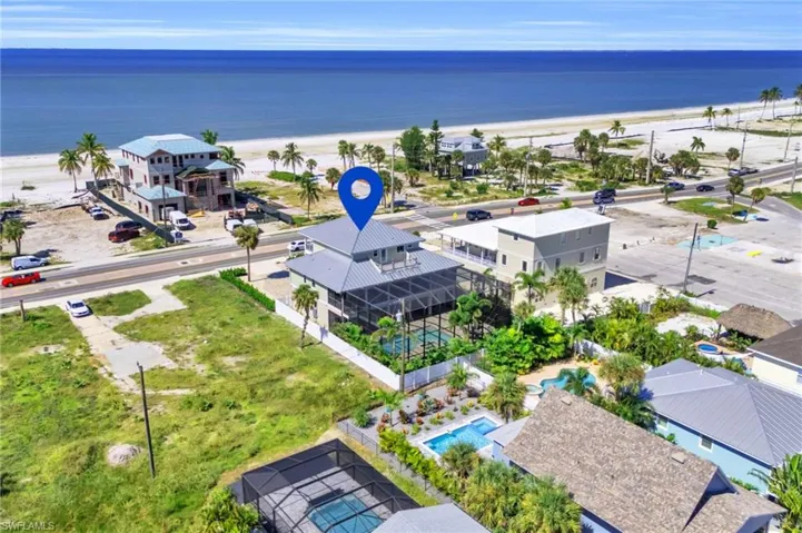 Aerial view featuring a water view and a beach view VIRTUALLY ENHANCED