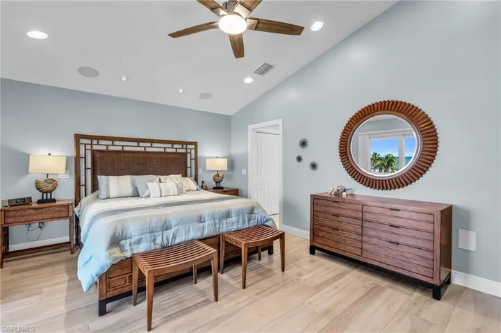Bedroom featuring high vaulted ceiling, a closet, light hardwood / wood-style floors, and ceiling fan /  virtually enhanced photo