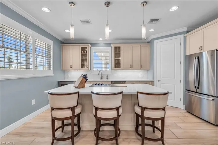 Kitchen featuring appliances with stainless steel finishes, a healthy amount of sunlight, a kitchen island, and sink /  virtually enhanced photo