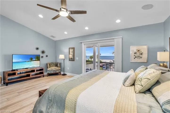 Primary Bedroom featuring ceiling fan, light hardwood / wood-style flooring, and access to exterior /  virtually enhanced photo
