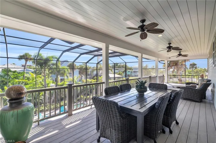 Wooden deck with glass enclosure and ceiling fan /  virtually enhanced photo