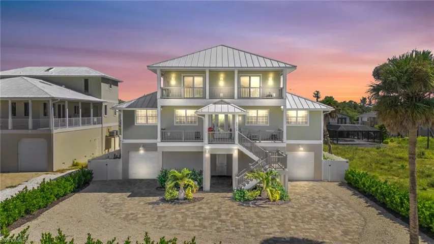 VIRTUALLY ENHANCED - View of front of home featuring a balcony, a garage, and covered porch