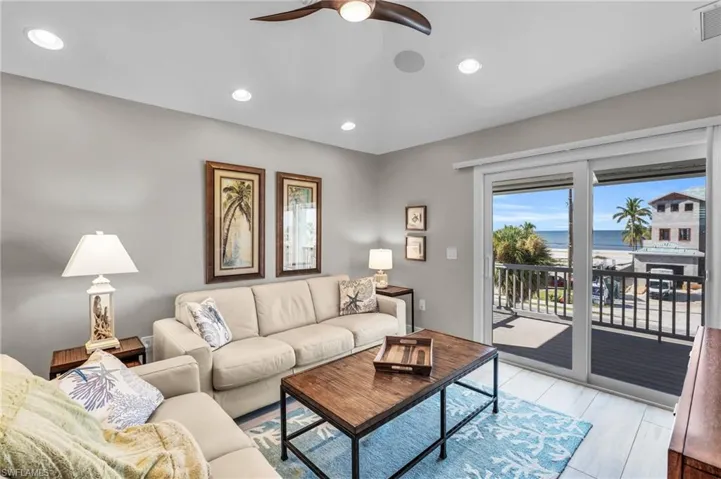 Living room with ceiling fan and a water view /  virtually enhanced photo
