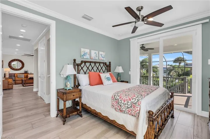 Bedroom with access to outside, crown molding, ceiling fan, and light hardwood / wood-style flooring.  virtually enhanced photo
