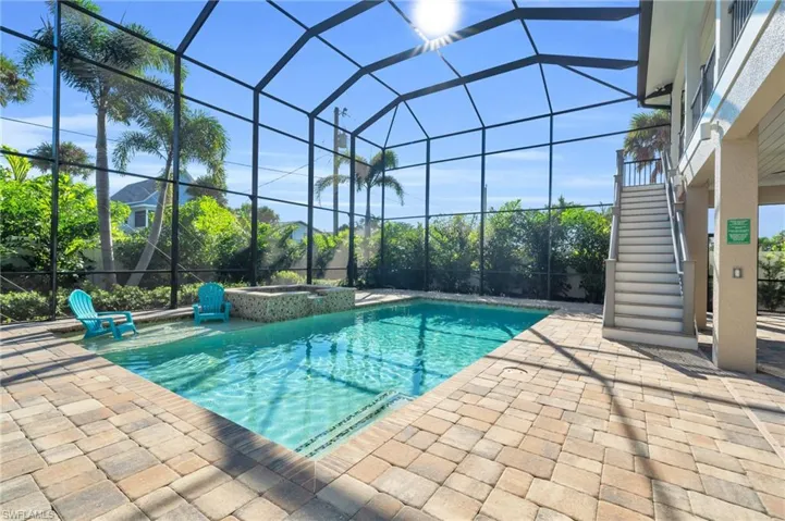 View of pool with an in ground hot tub, glass enclosure, and a patio VIRTUALLY ENHANCED