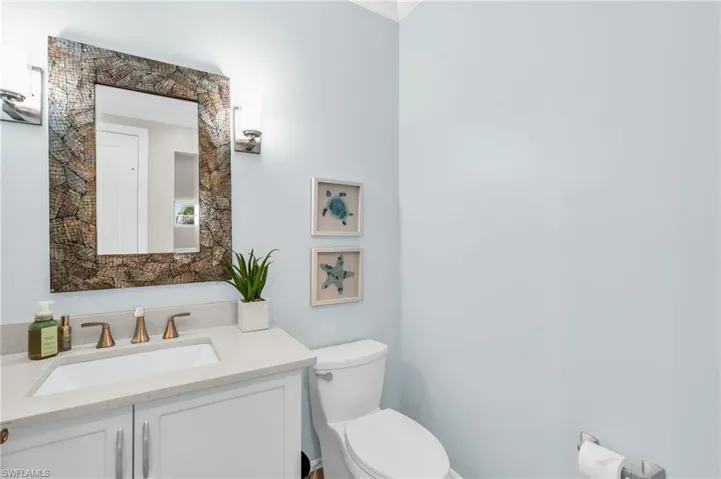 Bathroom featuring vanity and toilet.  virtually enhanced photo
