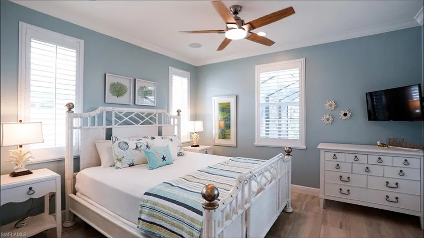 Bedroom with ceiling fan, hardwood / wood-style floors, and ornamental molding /  virtually enhanced photo