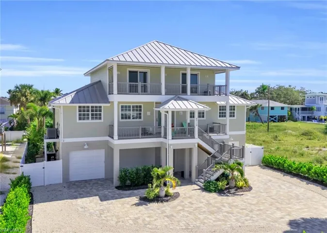 View of front of home with a balcony, a garage, and central AC unit VIRTUALLY ENHANCED