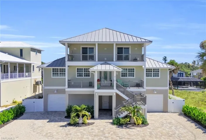 Coastal home featuring a balcony and a garage VIRTUALLY ENHANCED