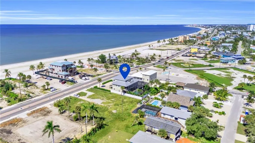 Drone / aerial view with a water view and a beach view VIRTUALLY ENHANCED