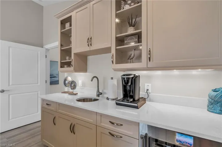 Kitchen featuring beverage cooler, light hardwood / wood-style flooring, and sink /  virtually enhanced photo