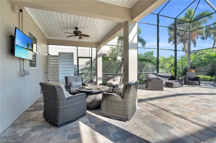 View of patio featuring ceiling fan, an outdoor hangout area, and glass enclosure VIRTUALLY ENHANCED