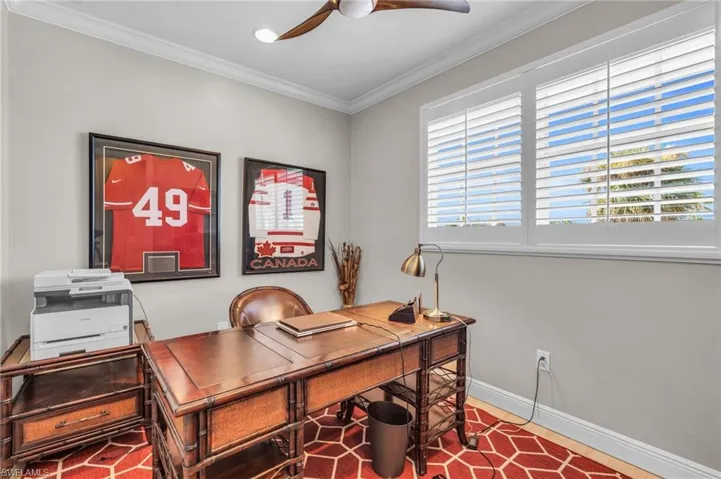 Office featuring ceiling fan and ornamental molding /  virtually enhanced photo