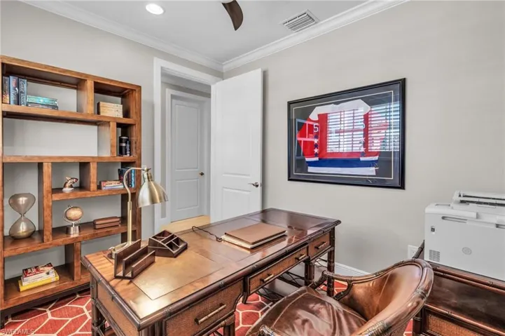 Office area featuring crown molding and ceiling fan /  virtually enhanced photo