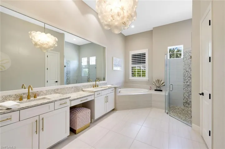 Bathroom with vanity, shower with separate bathtub, an inviting chandelier, and tile patterned flooring