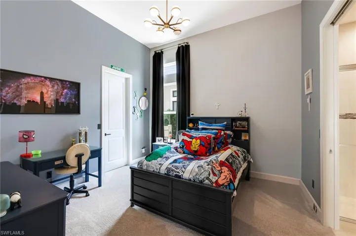 Bedroom with light carpet and an inviting chandelier