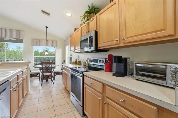 Kitchen with appliances with stainless steel finishes, light countertops, hanging light fixtures, recessed lighting, and light tile patterned floors