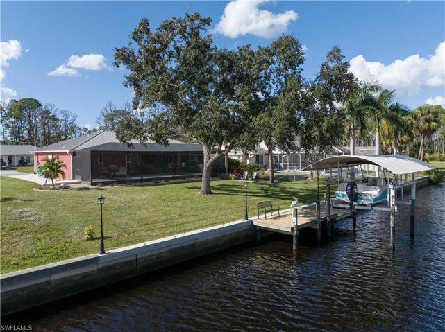 Low aerial view of home, backyard and boat dock and lift
