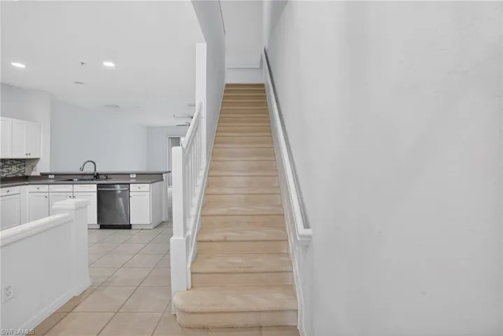Carpeted staircase with white balusters